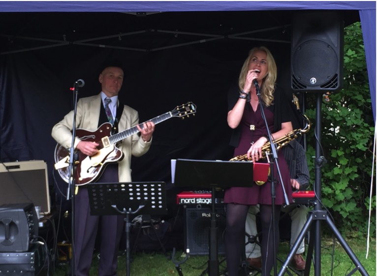 Pastiche Jazz trio playing at a London garden party. Simon Nelson, guitar and vocals; Lindsay Goodhand, sax and vocals